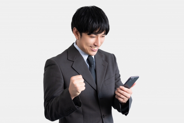 スマホを見て喜ぶ男性